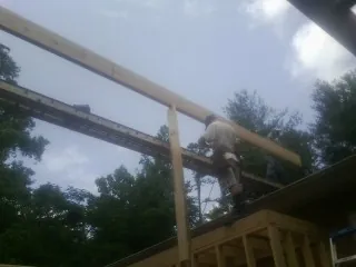 Carpenter setting a ridge beam over a new addition frame — Ice Dam Removal by Roofing Brothers in Kilbourne