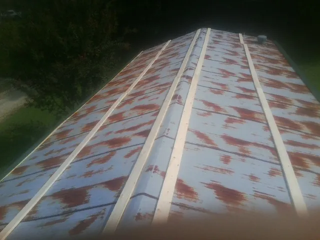 Rusted metal roof panels with new wood purlins before replacement — Storm Damage Roof Repair in Kilbourne by Roofing Brothers