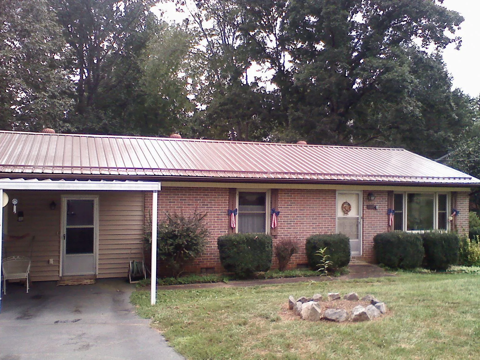 Bronze metal roof and carport on a brick ranch home — Roof Repair work by our crew in Kilbourne